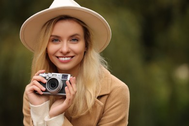 Photo of Autumn vibes. Portrait of happy woman with camera outdoors, space for text