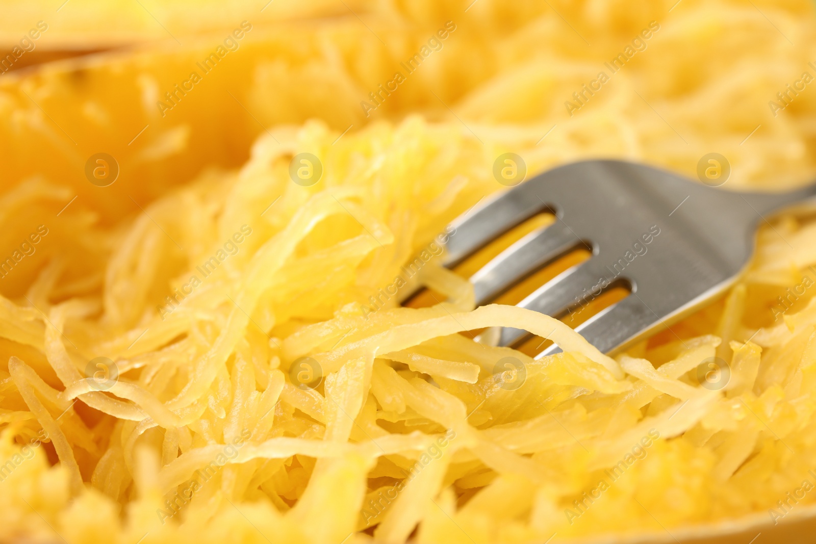 Photo of Tasty cooked spaghetti squash and fork, closeup