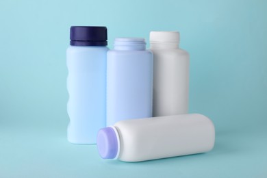 Photo of Baby powder in bottles on turquoise background. Space for text