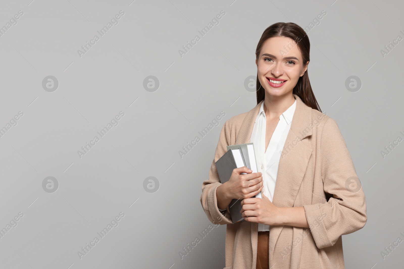 Photo of Portrait of beautiful young teacher on grey background. Space for text