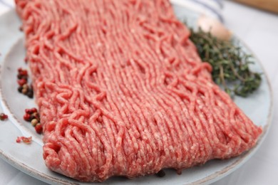 Fresh raw ground meat and spices on table, closeup