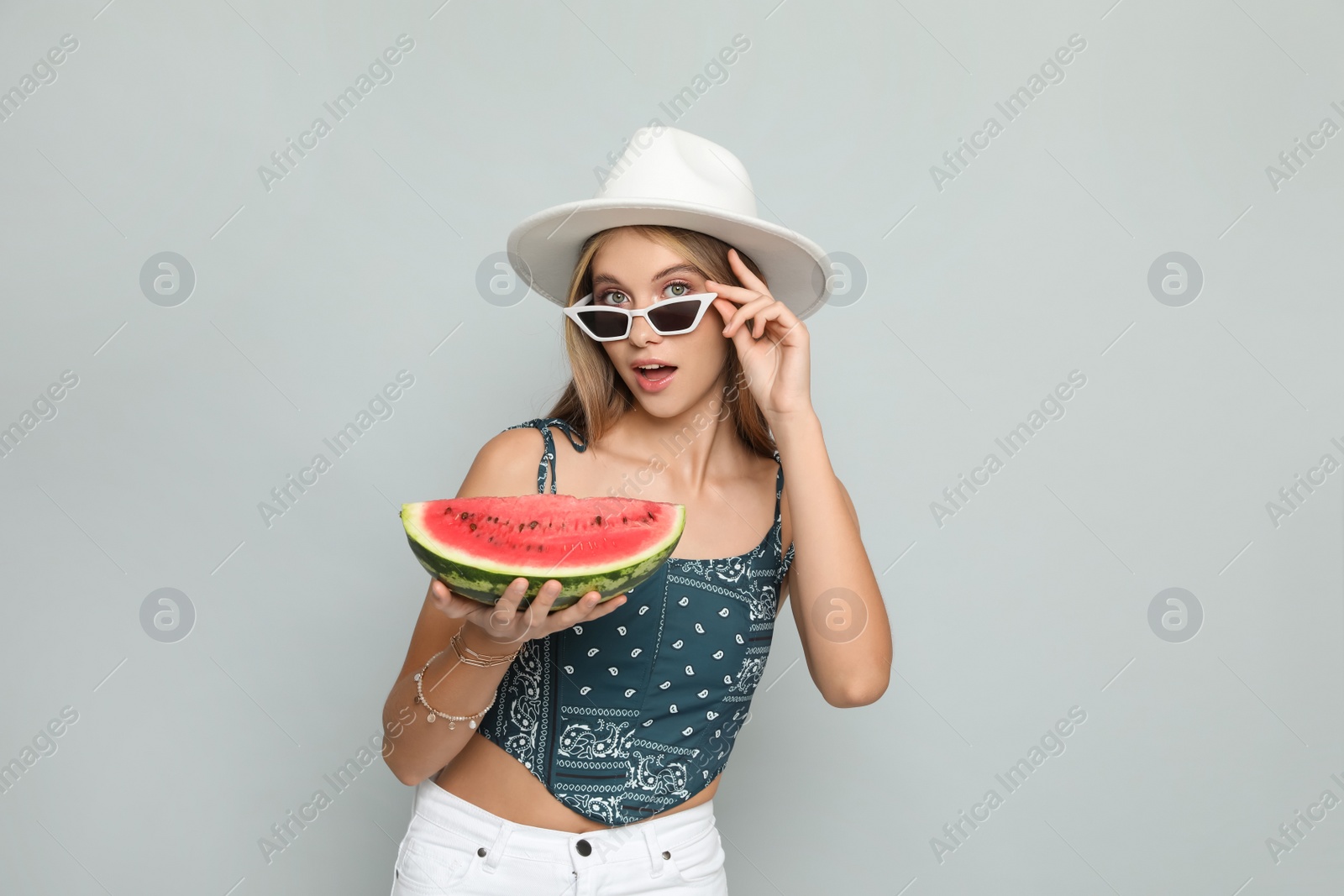 Photo of Beautiful girl with watermelon on grey background