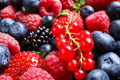 Photo of Mix of different ripe tasty berries as background, closeup view