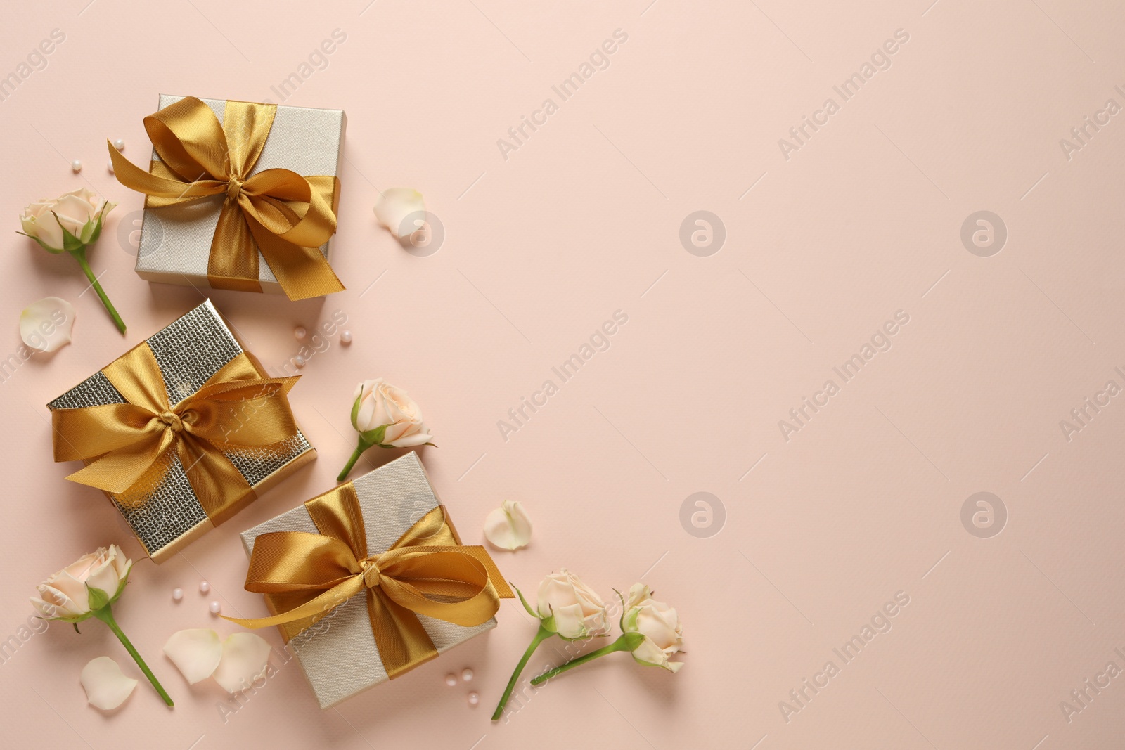 Photo of Beautiful gift boxes and flowers on pink background, flat lay. Space for text