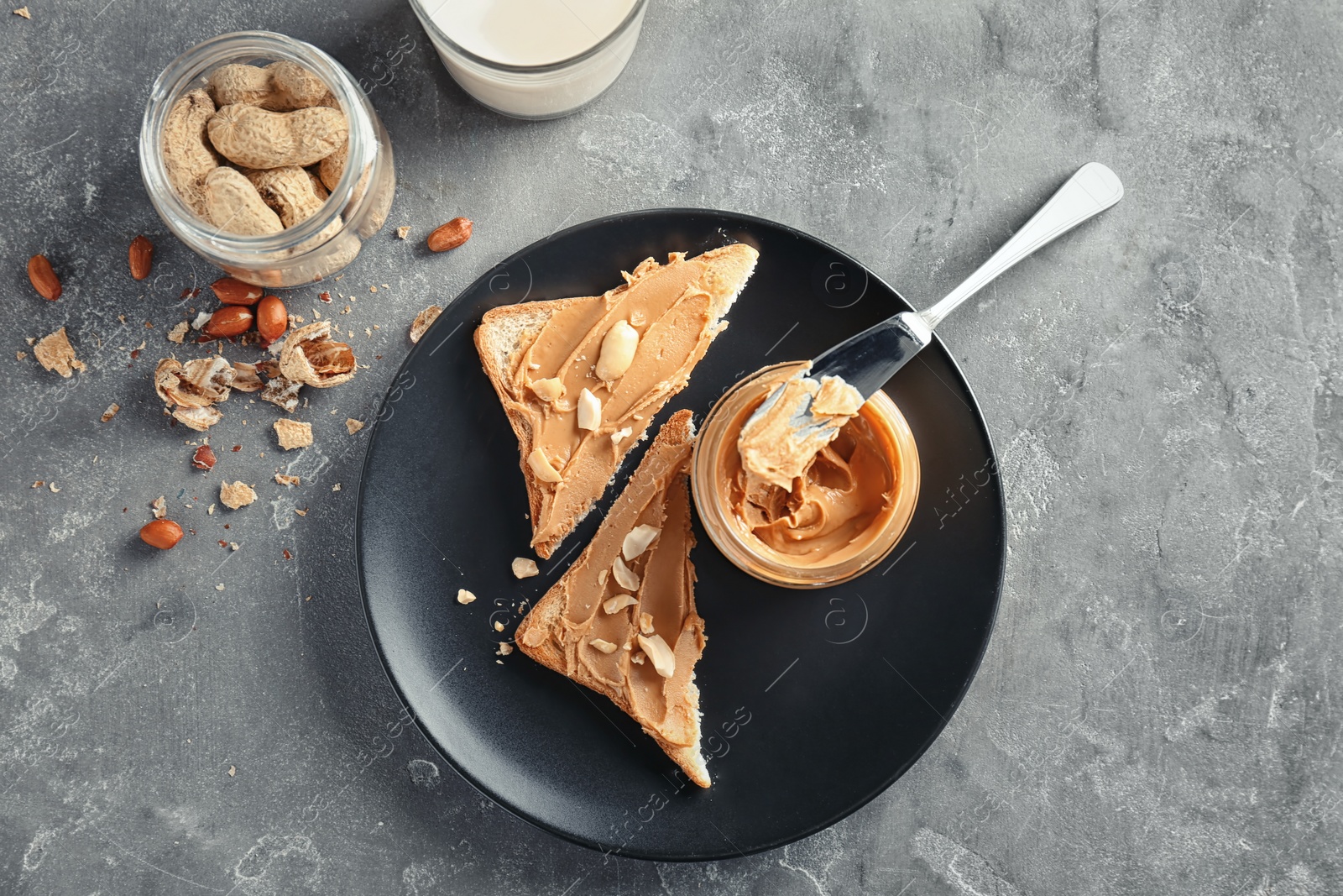 Photo of Jar with creamy peanut butter and toasts on plate