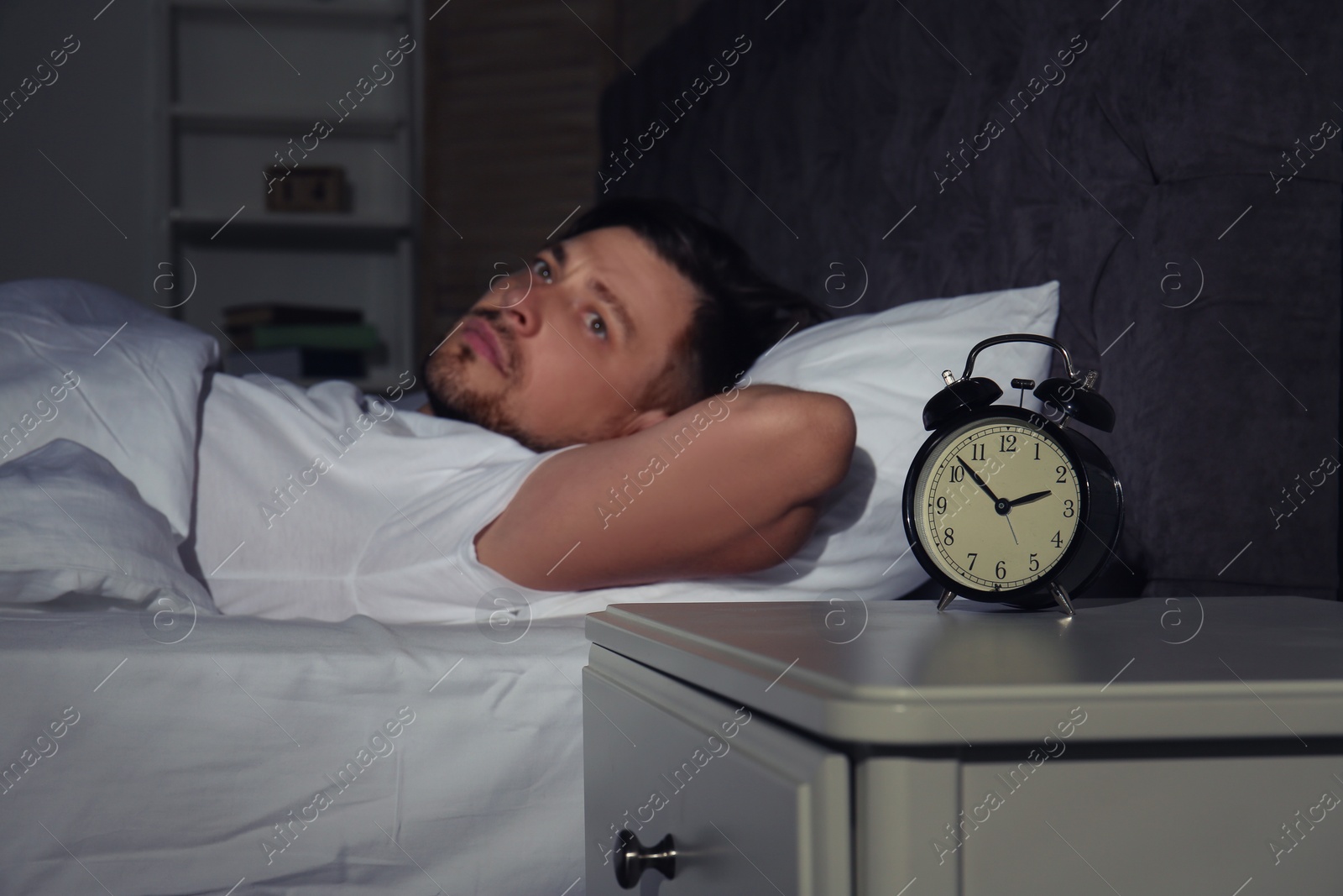 Photo of Man suffering from insomnia in bed at home