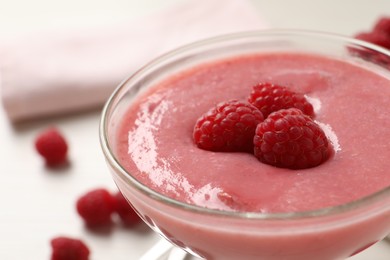 Photo of Delicious raspberry mousse in glass dish, closeup view