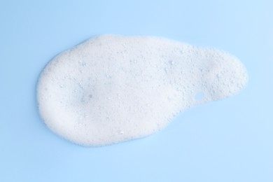 Sample of fluffy foam on light blue background, top view