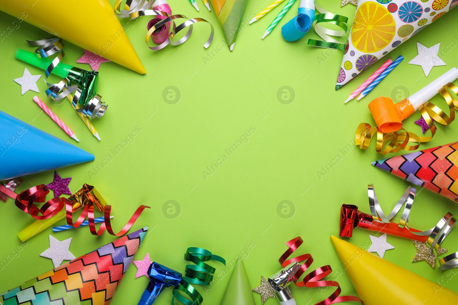 Photo of Frame of different accessories for birthday party on green background, flat lay. Space for text