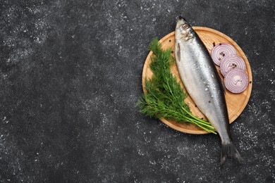 Photo of Delicious salted herring, dill and onion on dark grey table, top view. Space for text