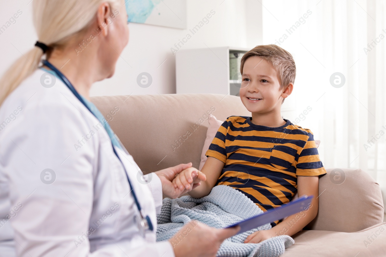 Photo of Family doctor visiting ill child at home