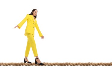 Image of Businesswoman walking rope against white background. Risk or balance concept
