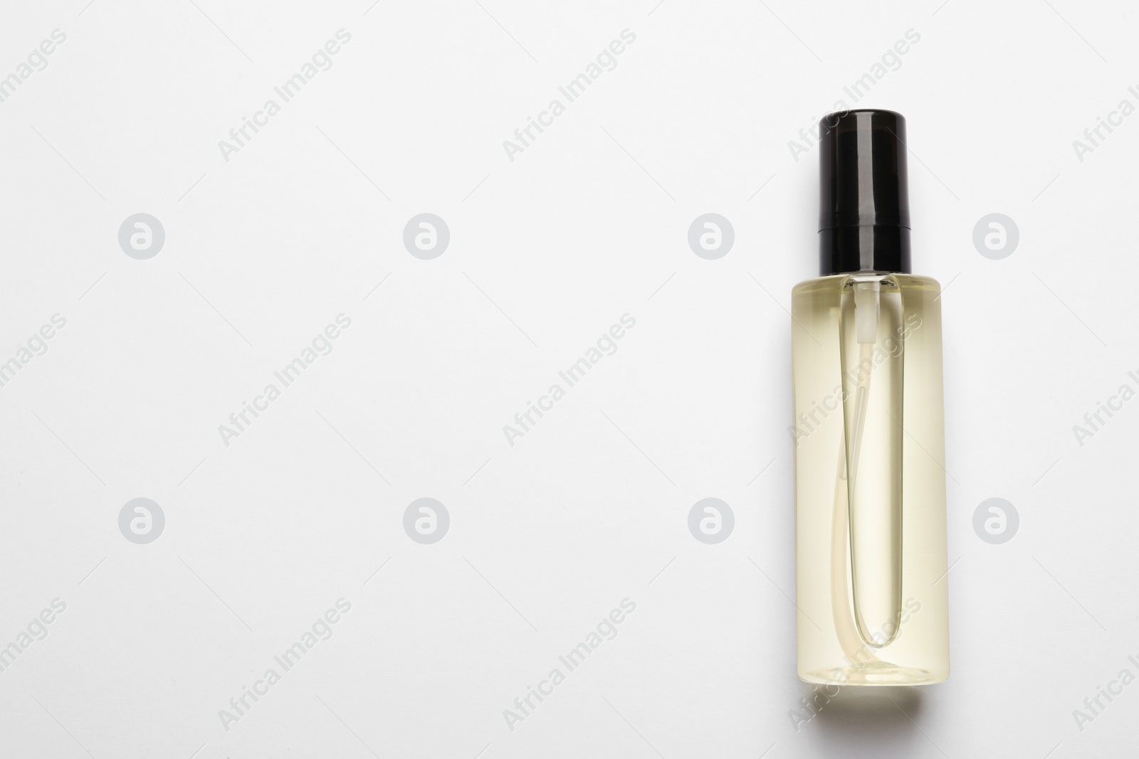 Photo of Bottle of baby oil on white background, top view. Space for text