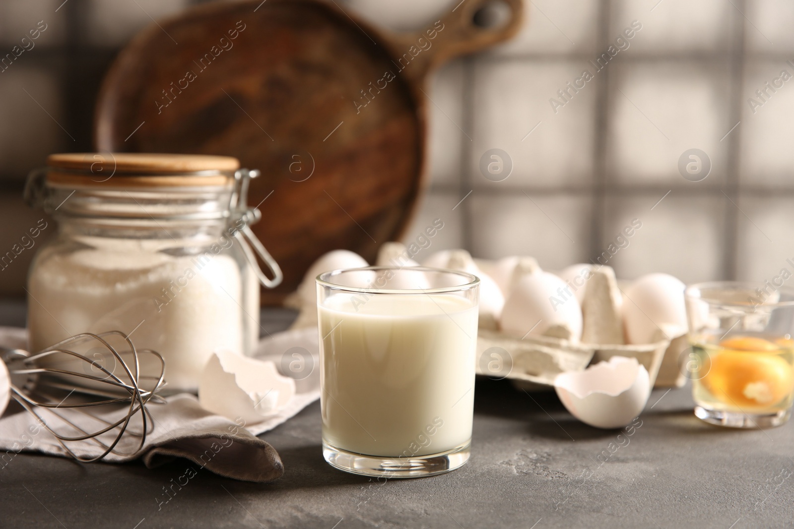 Photo of Different ingredients for dough on grey table, closeup