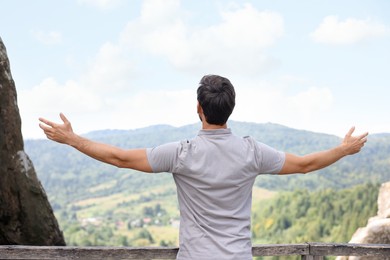 Photo of Man feeling freedom by enjoying mountain landscape, back view
