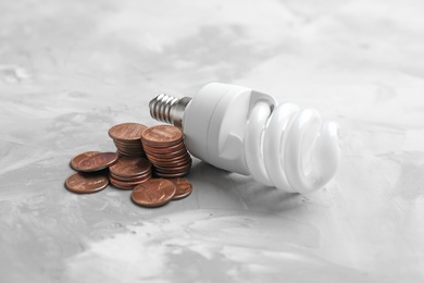 Photo of Light bulb and many coins on table
