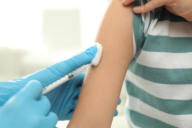 Doctor vaccinating little child in clinic, closeup