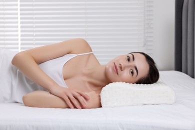 Photo of Woman lying on orthopedic pillow at home