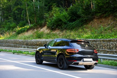 Photo of Picturesque view of asphalt road with modern black car