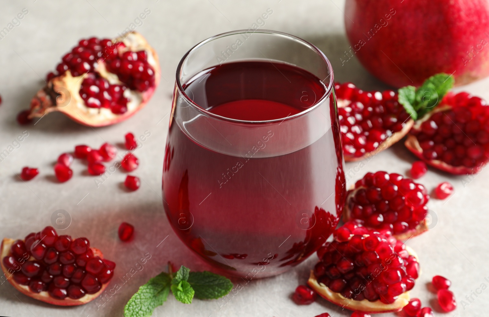 Photo of Composition with glass of fresh pomegranate juice on table