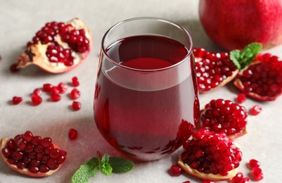 Photo of Composition with glass of fresh pomegranate juice on table