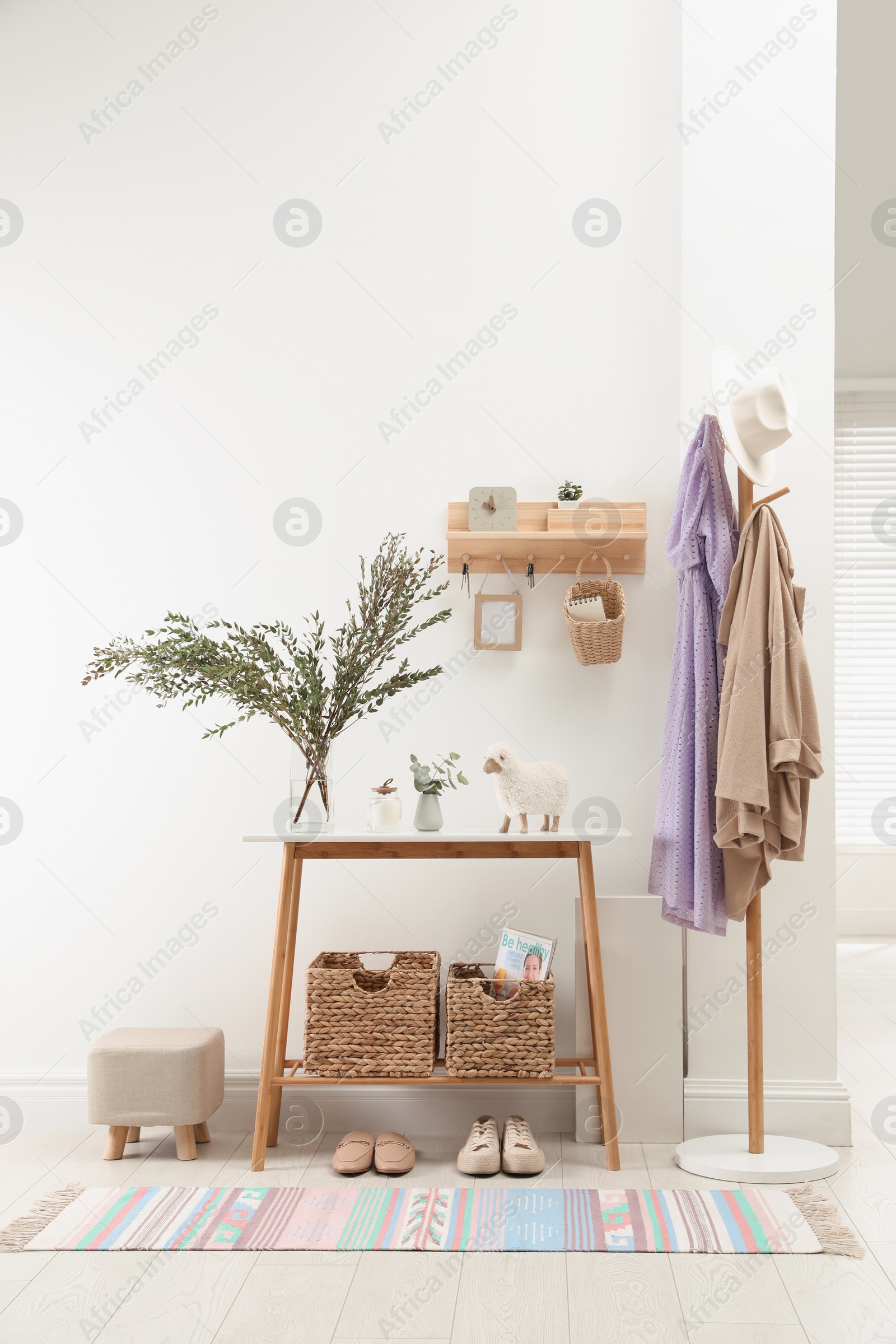 Photo of Modern hallway interior with table, clothes rack and key holder