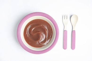 Photo of Healthy baby food, fork and spoon on white background, flat lay