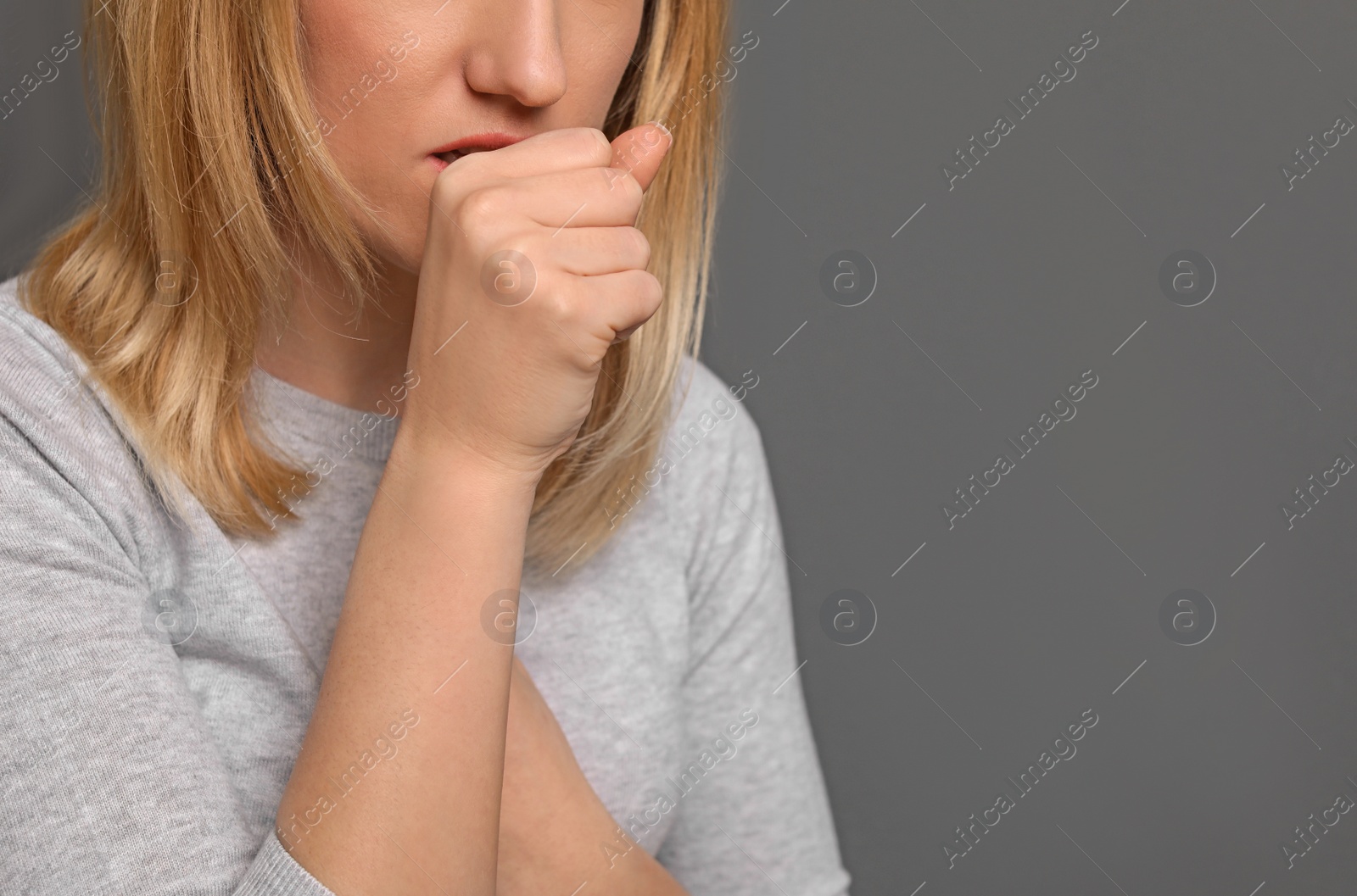 Photo of Young woman coughing on grey background