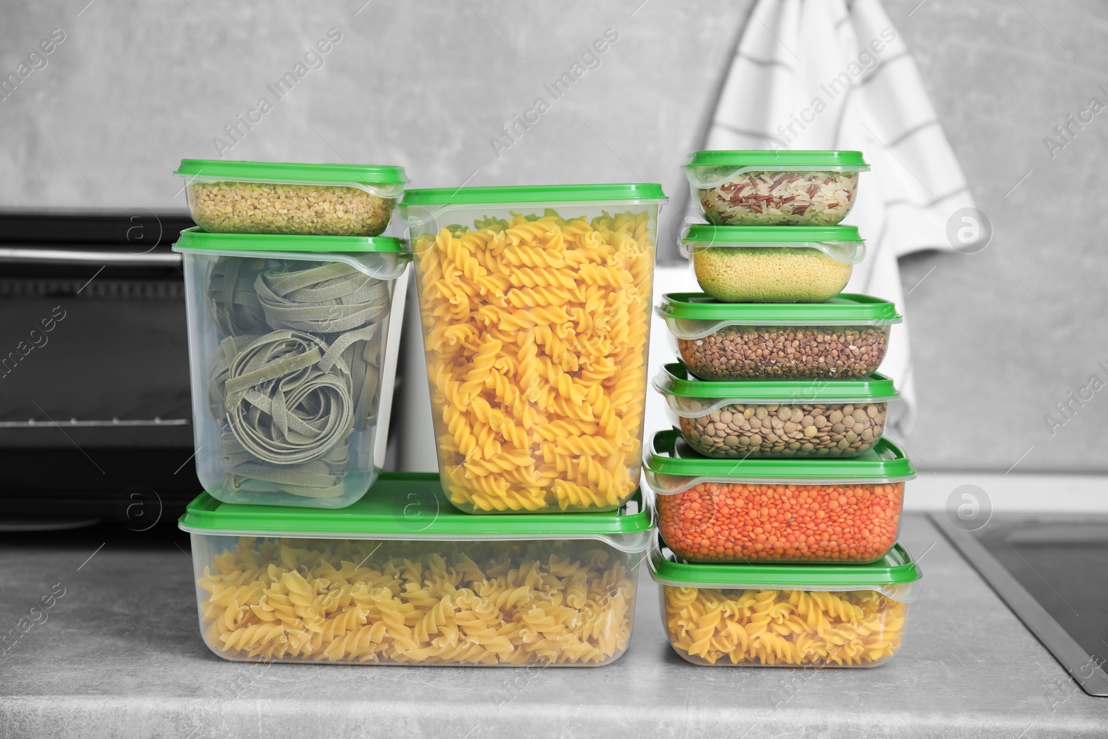 Photo of Plastic containers filled with food products on light grey countertop in kitchen