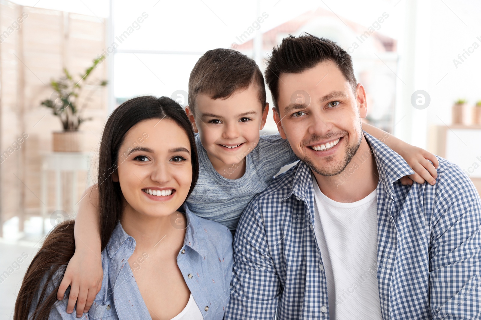 Photo of Happy couple and their son at home. Family time