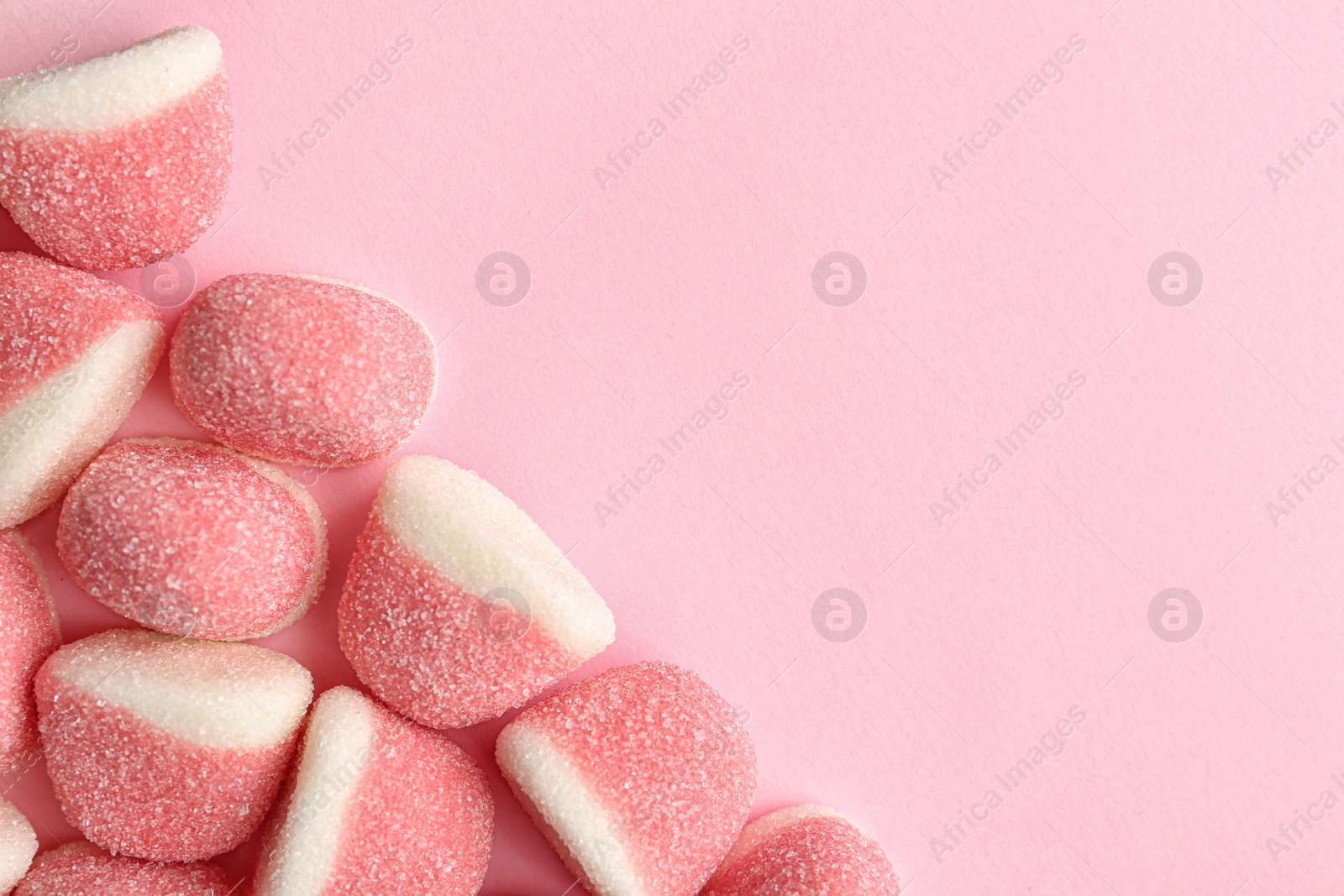 Photo of Sweet jelly candies on pink background, top view. Space for text