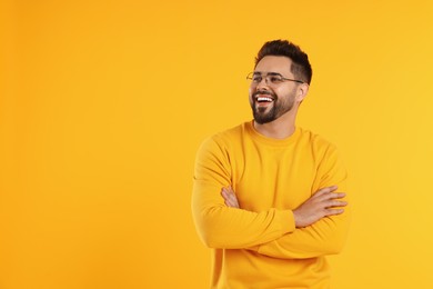 Photo of Handsome man wearing glasses on orange background, space for text