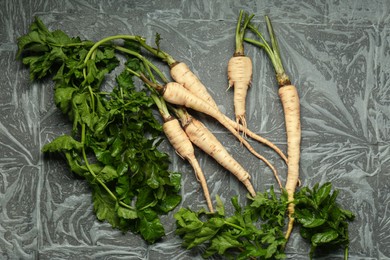 Tasty fresh ripe parsnips on grey table, flat lay