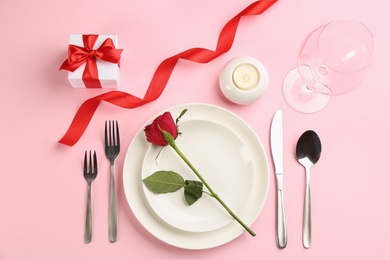 Photo of Beautiful table setting for Valentine's Day dinner on pink background, flat lay