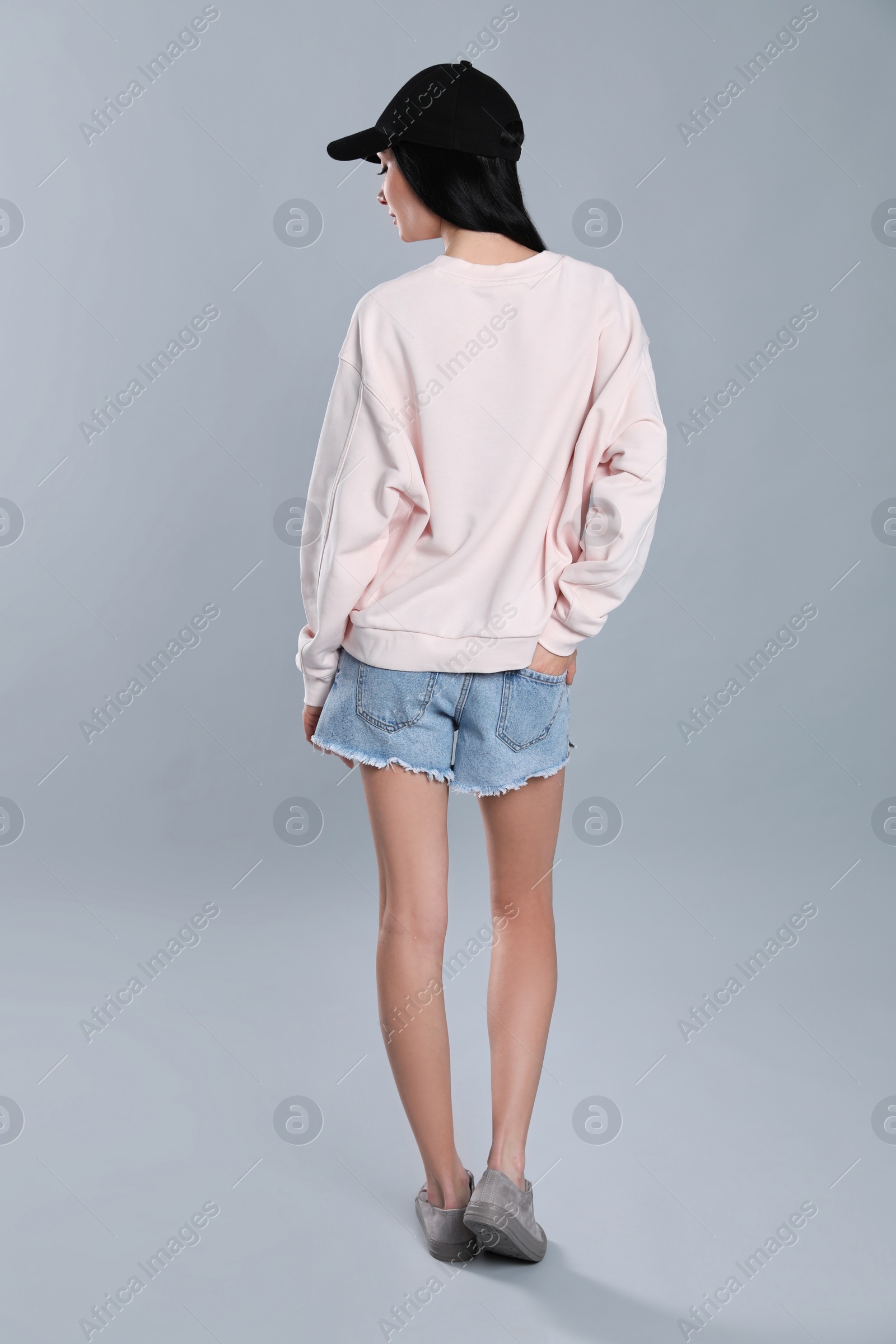 Photo of Young woman in sweater on grey background. Mock up for design