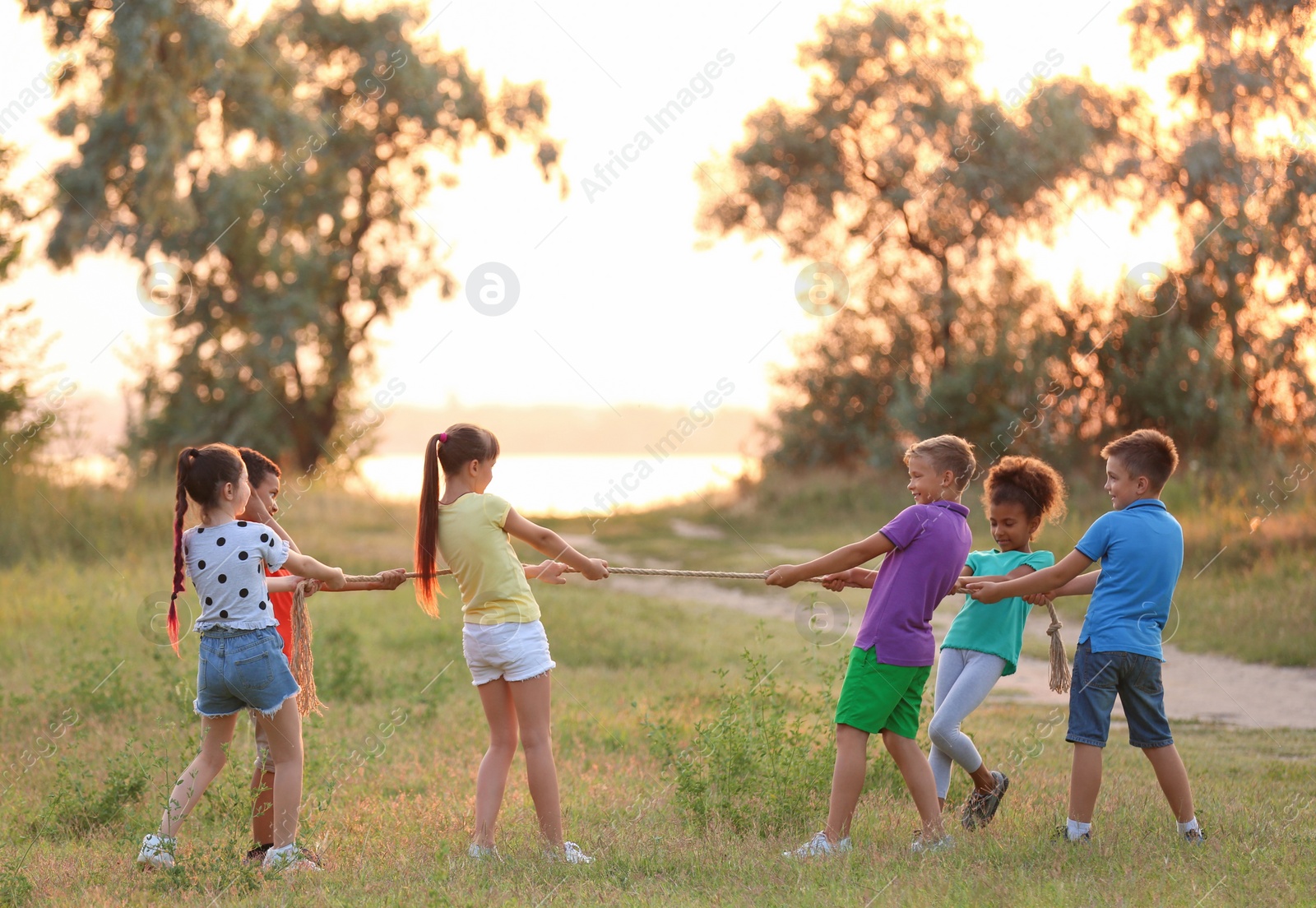 Photo of Cute little children playing outdoors at sunset