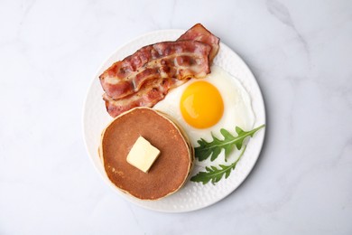 Photo of Tasty pancakes with fried egg and bacon on white table, top view