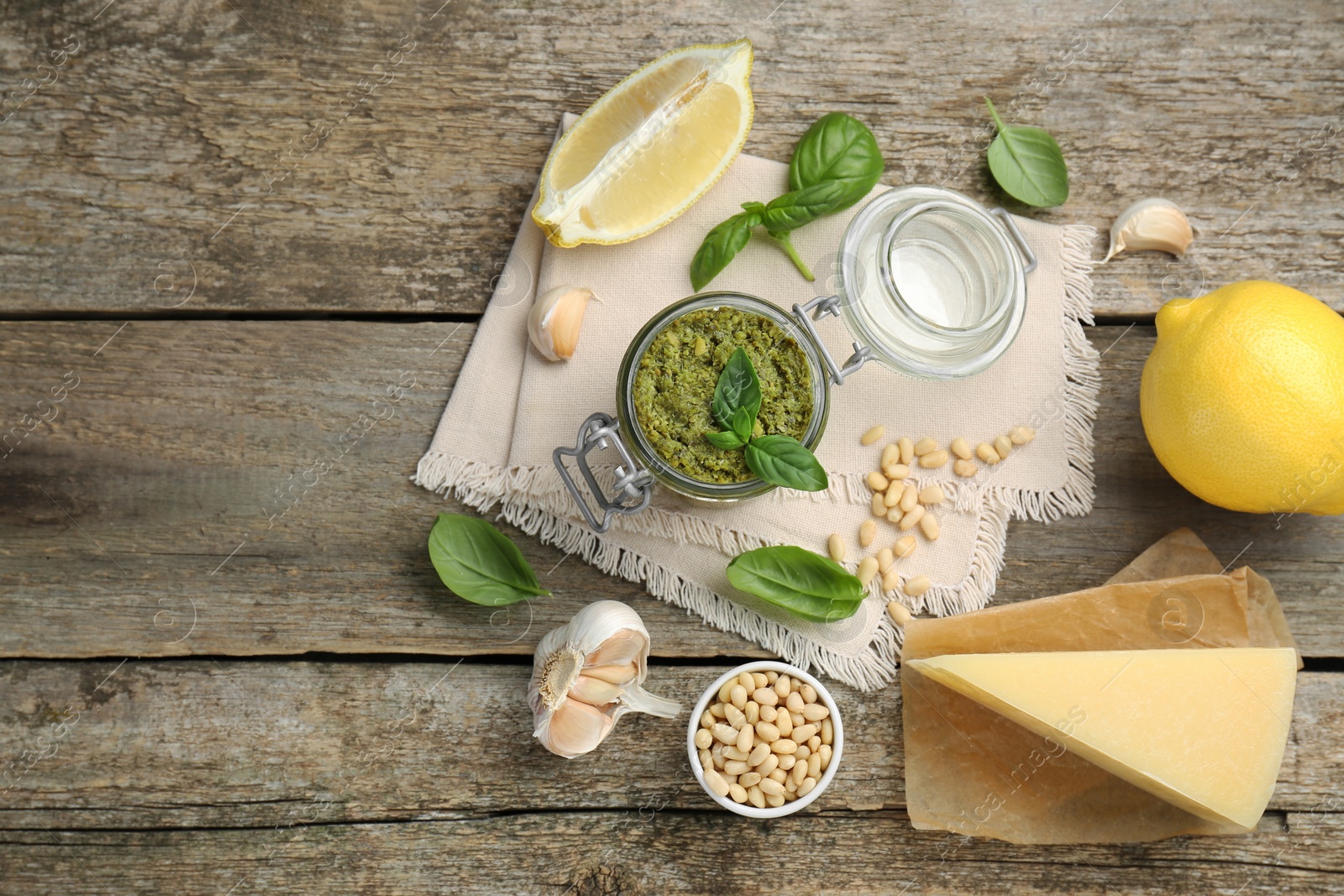 Photo of Delicious pesto sauce and ingredients on wooden table, flat lay. Space for text