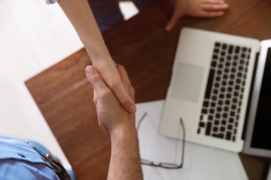 Photo of Business partners shaking hands over table after meeting, top view