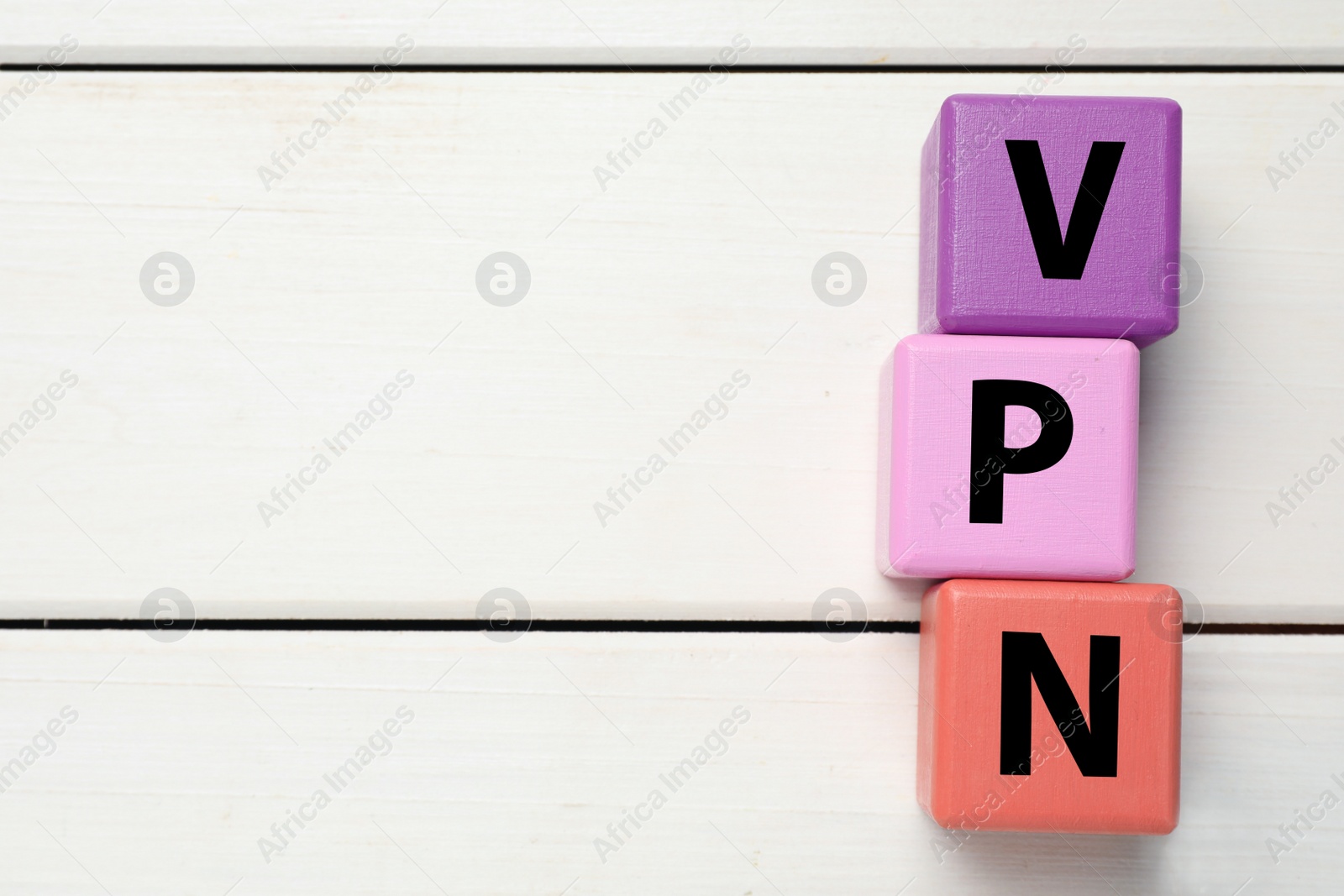 Image of Color cubes with acronym VPN on white wooden background, flat lay. Space for text