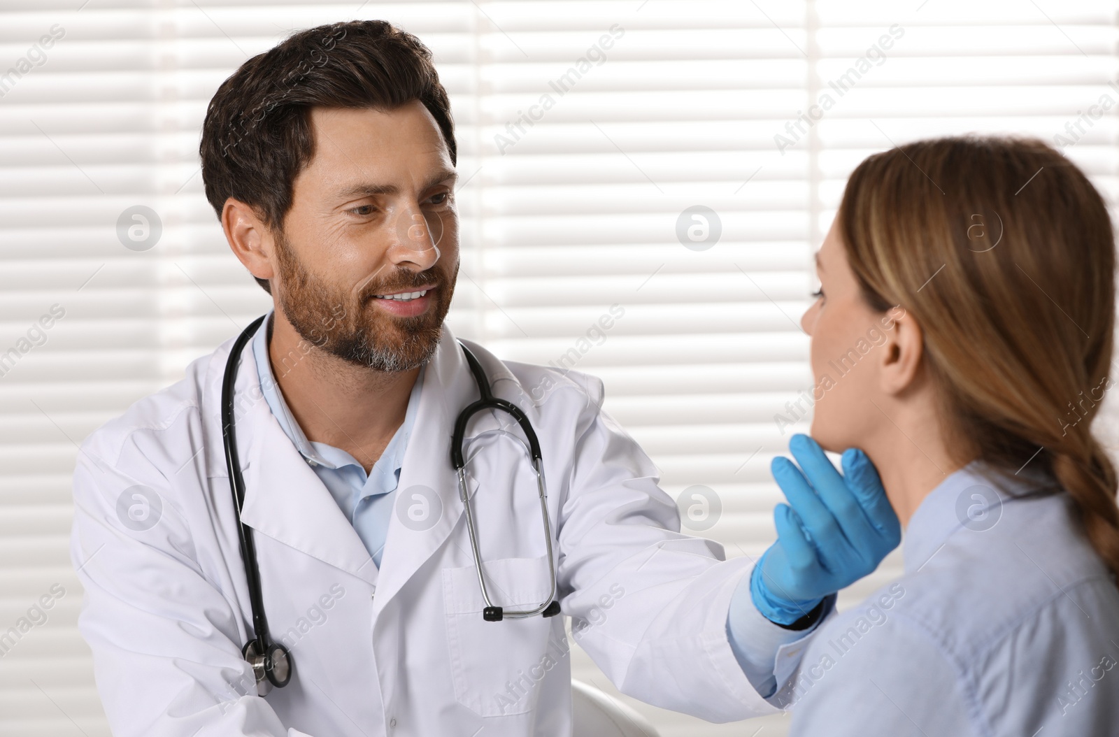 Photo of Doctor in medical gloves examining woman`s oral cavity indoors
