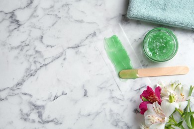 Flat lay composition with wax and spatula on white marble table. Space for text