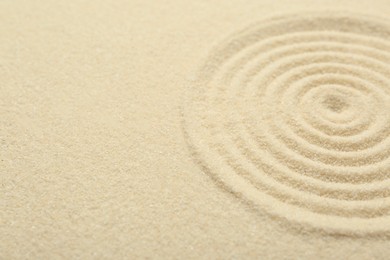 Photo of Zen rock garden. Circle pattern on beige sand