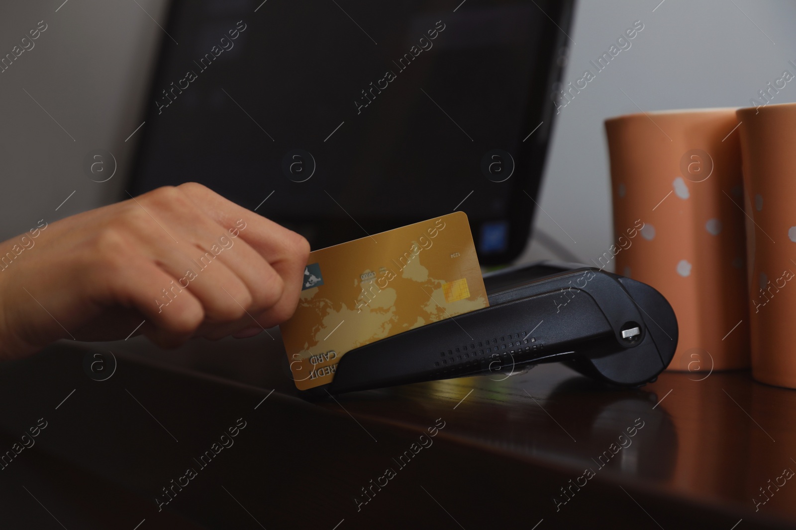 Photo of Woman using credit card machine for non cash payment in cafe, closeup