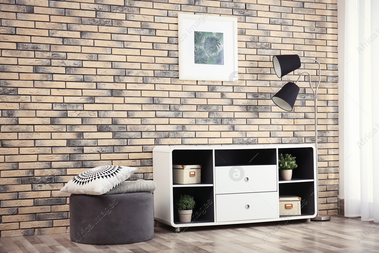 Photo of Elegant room interior with stylish shelving unit and ottoman