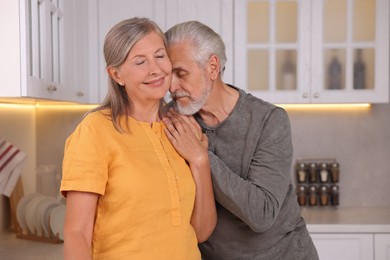 Photo of Portrait of affectionate senior couple in kitchen