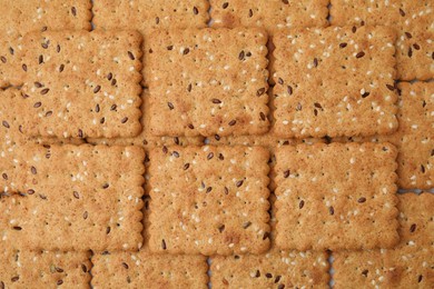 Photo of Cereal crackers with flax and sesame seeds as background, top view