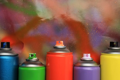 Photo of Cans of different graffiti spray paints on color background, flat lay. Space for text
