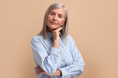 Photo of Portrait of beautiful middle aged woman on beige background