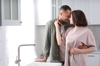 Photo of Dating agency. Happy couple spending time together in kitchen, space for text